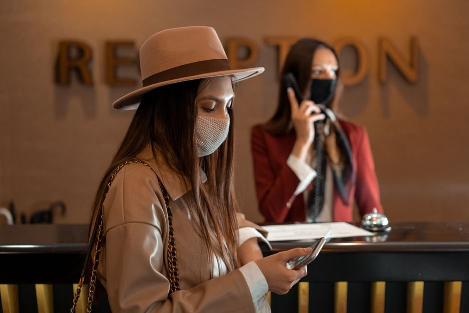 Recepcionista entregando chave de quarto para hóspede na chegada