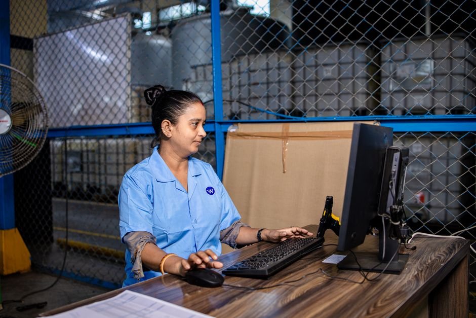 Trabalhador em galpão industrial conferindo produção
