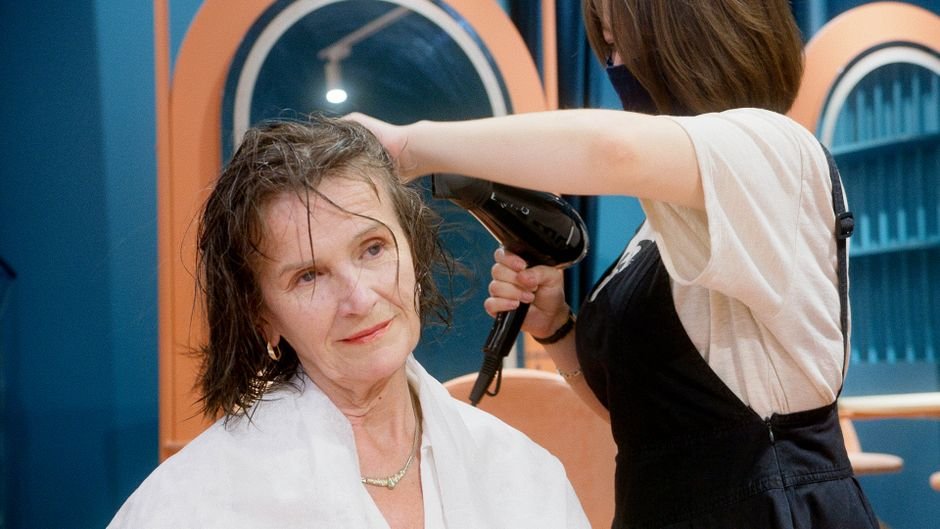 Cliente sendo atendida em cadeira de salão para corte e escova combinados