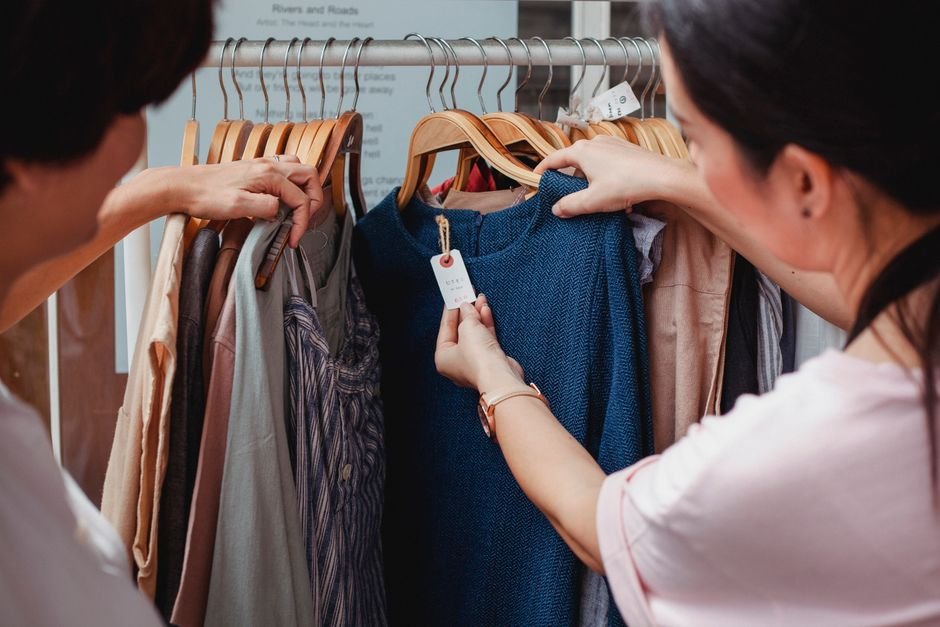 Arara de roupas organizada por tamanho e cor em loja de moda