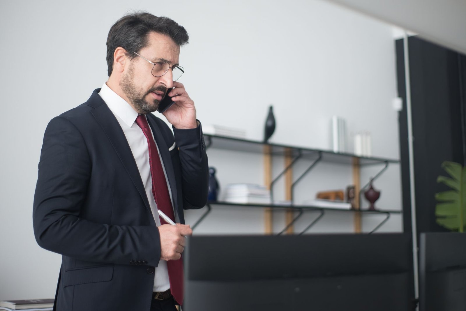 Empresário sério ao telefone em escritório