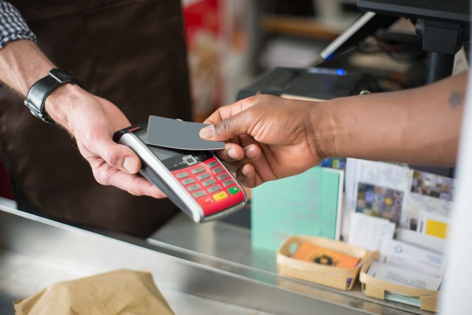 Cliente pagando compra com cartão de crédito em maquininha