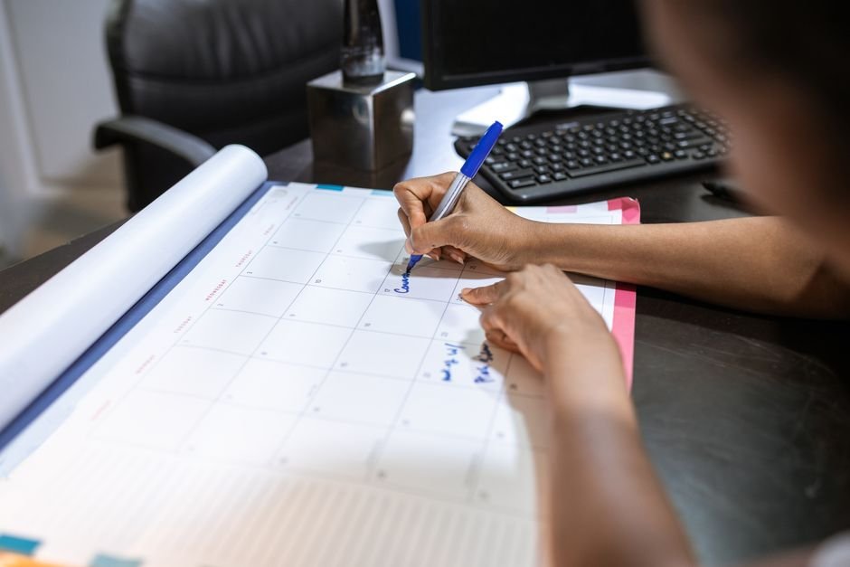 Calendário anual com marcações de temporada sobre mesa de planejamento