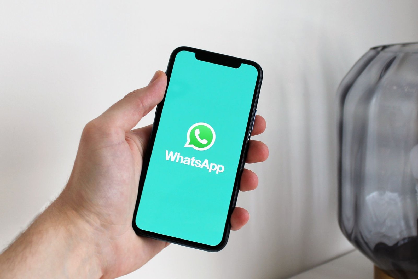 Pessoa segurando celular com aplicativo de mensagens aberto
