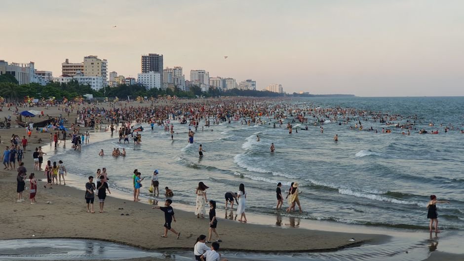 Praia lotada de turistas em dia de alta temporada