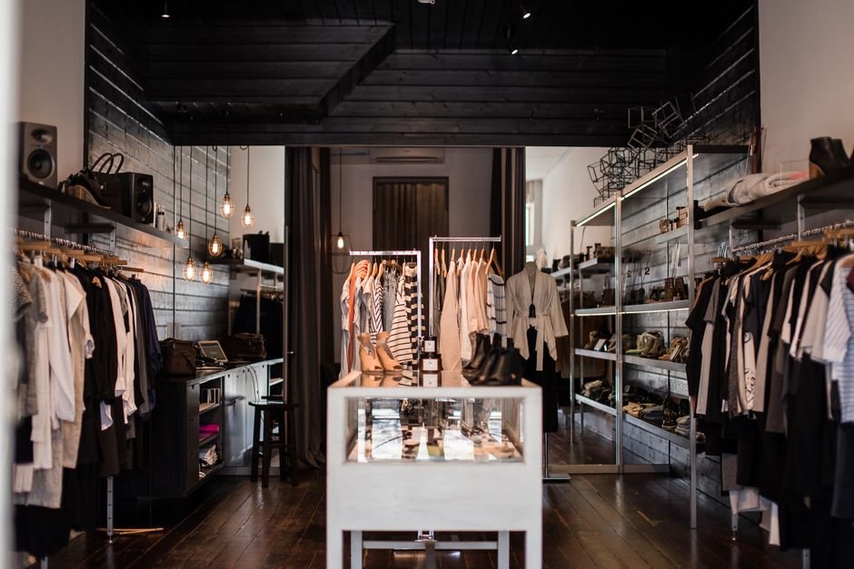 Estilista organizando peças de roupa em ateliê de moda